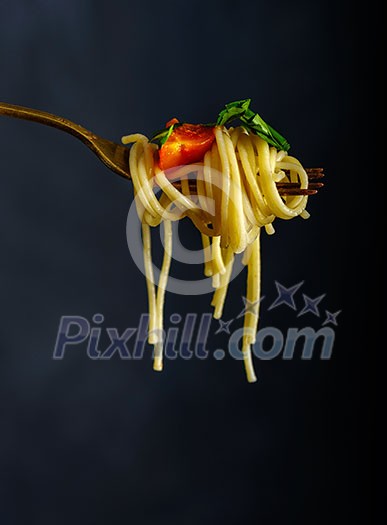 Spaghetti on a fork. Pasta with fresh tomatoes and herbs Spaghetti on a fork. Pasta with fresh tomatoes and herbs