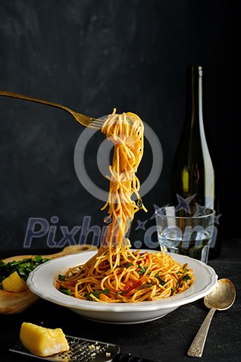 Spaghetti on a fork. Pasta with fresh tomatoes and herbs