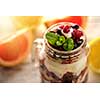 Muesli, fresh berries and yogurt in glass mason jar. Healthy breakfast with Homemade granola. Selective focus.