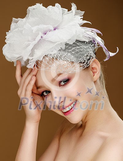 Beautiful girl in a wedding hat. Beige background. Beautiful girl in a wedding hat. Beige background.