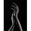 Dark-skinned hands over black background. Beautiful hands