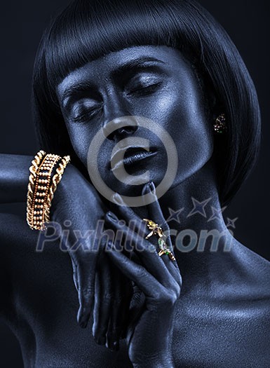 Fashion portrait of a dark-skinned beautiful girl with jewerly. Black Beauty face. Picture taken in the studio on a black background.