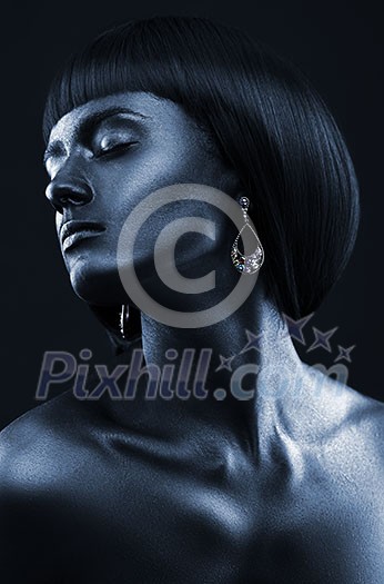 Black Beauty face. Fashion portrait of a dark-skinned beautiful girl with jewerly. Picture taken in the studio on a black background.