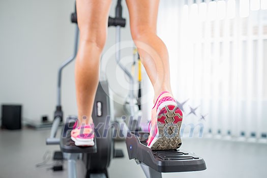 Young woman's muscular legs on stepper/treadmill, closeup Young woman's muscular legs on stepper/treadmill, closeup
