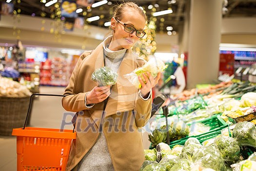 Pretty, young woman shopping for fresh vegetables at a grocery store Pretty, young woman shopping for fresh vegetables at a grocery store