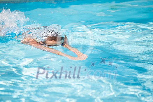 Pretty female swimmer in a pool, getting her daily dose of exercise without stressing her joints Pretty female swimmer in a pool, getting her daily dose of exercise without stressing her joints