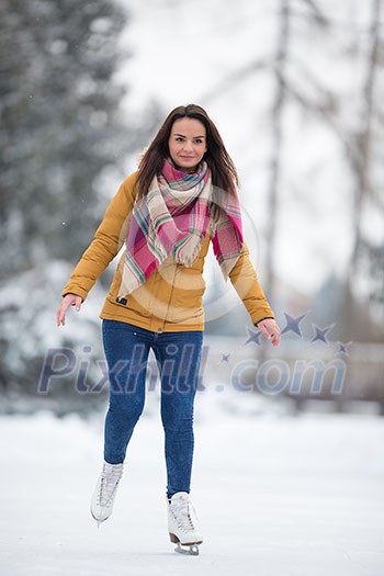 Young woman ice skating outdoors on a pond on a freezing winter day (color toned image; motion blurred image) Young woman ice skating outdoors on a pond on a freezing winter day (color toned image; motion blurred image)