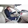 Woman driving a car - female driver at a wheel of a modern car, drinking her morning coffee (shallow DOF; color toned image)