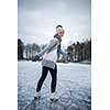 Young woman ice skating outdoors on a pond on a freezing winter day (color toned image; motion blurred image)