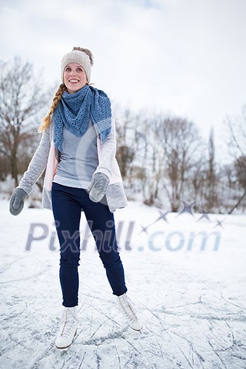 Young woman ice skating outdoors on a pond on a freezing winter day (color toned image; motion blurred image)