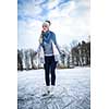 Young woman ice skating outdoors on a pond on a freezing winter day (color toned image; motion blurred image)