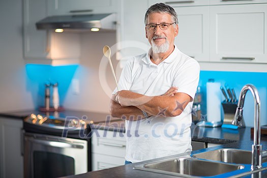 Senior man standing in his renovated, modern kitchen,