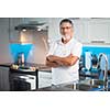 Senior man standing in his renovated, modern kitchen,