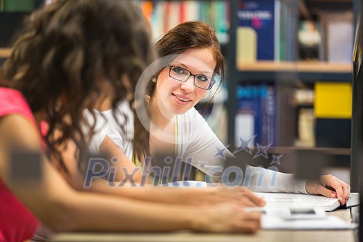 Group of university students studying hard for an exam in a lovely bright sunlit studying room/library