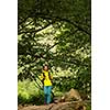 Pretty, young female hiker walking through a splendid old forest (shallow DOF)