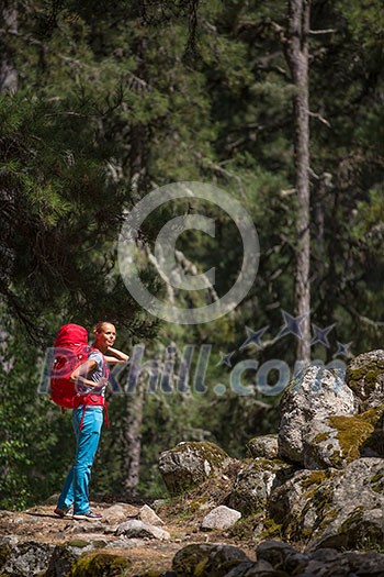Pretty, young female hiker walking through a splendid old pine forest (shallow DOF) Pretty, young female hiker walking through a splendid old pine forest (shallow DOF)
