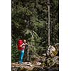 Pretty, young female hiker walking through a splendid old pine forest (shallow DOF)