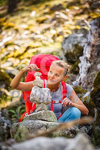 Pretty, young female hiker walking in high mountains (shallow DOF)