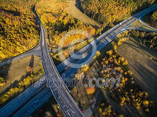 Aerial view of a highway amid fields with cars on it Aerial view of a highway amid fields with cars on it