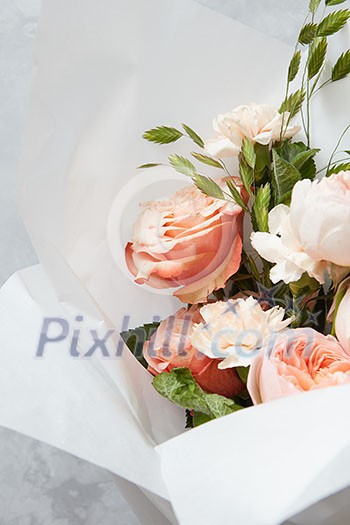 Composition of flowers of white or orange roses represented on grey background. Decoration of grey background in Valentine's Day. Holiday concept.