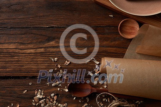 Wooden utensils for cooking and parchment paper on a wooden table Wooden utensils for cooking and parchment paper on a wooden table