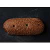 single whole full rye dark bread isolated on black background