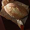 Loaf of bread over cooking paper over wooden background. Delicious white bread for having breakfast, dinner, lunch, etc.