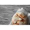 Homemade rye artisan sourdough bread over white wooden background. Top view of bread represented on cooking paper. Blank copy space for noting your ideas and emotions.