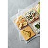 Top view of different kinds of colorful sandwiches on white chalkboard background. Party starter or appetizer - flat lay composition.