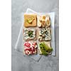 Party starter or appetizer - flat lay composition. Top view of different kinds of colorful sandwiches on white chalkboard background. Food industry concept.