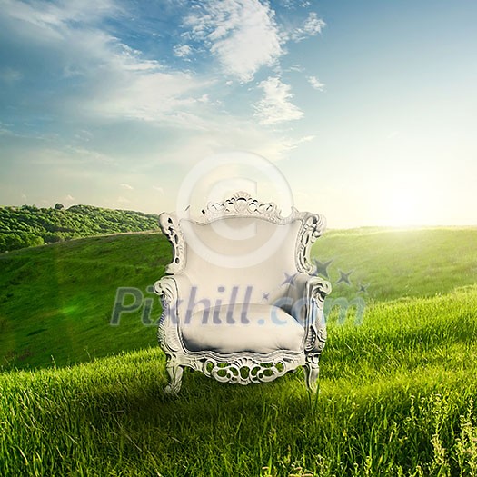 Arm chair represented on green grass with landscape on sunset. Beautiful dawn in spring or summer time. Landscape concept.