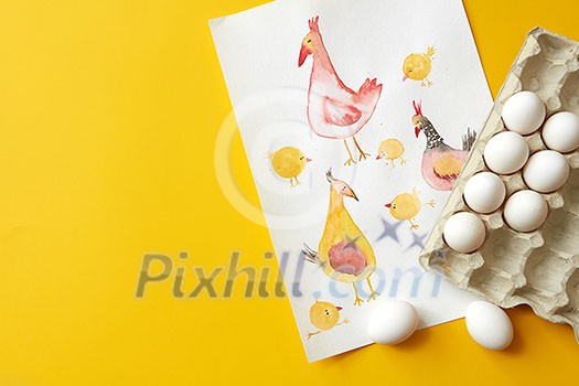 paper tray with eggs and chicken painted on a paper on the yellow background