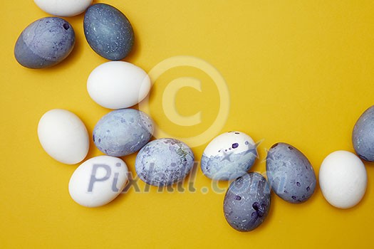 Corner frame of colored eggs on a yellow background