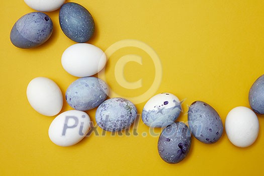 Corner frame of colored eggs on a yellow background Corner frame of colored eggs on a yellow background