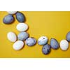 Corner frame of colored eggs on a yellow background