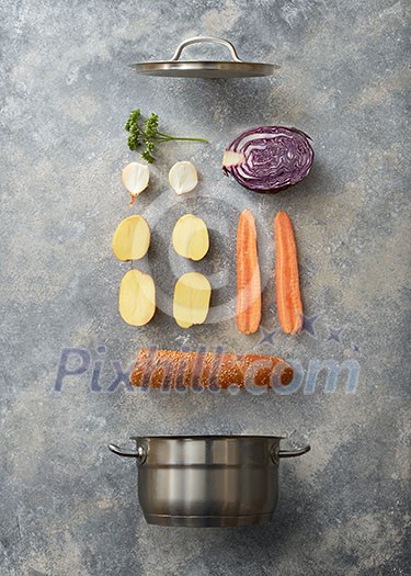 Open pan and sliced vegetables for cooking with baguette on a gray concrete background, flat lay Open pan and sliced vegetables for cooking with baguette on a gray concrete background, flat lay