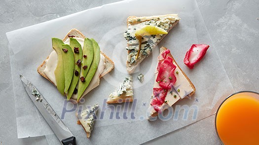 Toasts with cream cheese and avocado placed on paper. Top view Toasts with cream cheese and avocado placed on paper. Top view
