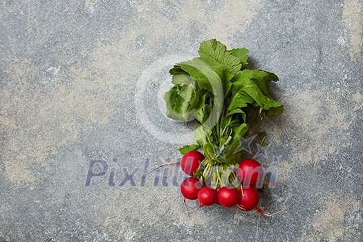 Heap of Radish with green leaves over stone background