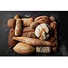 Different kinds of bread represented over black background. Fresh bread after baking: white and brown bread. Collection of wholegrain, sesame, grain, etc. bread. Bakery concept.