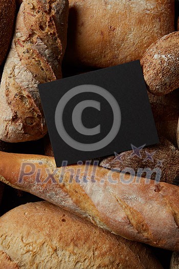 Top view of frame copy space of black color represented among different kinds of bread. Border of different bread sorts. Baking and cooking concept background. Top view of frame copy space of black color represented among different kinds of bread. Border of different bread sorts. Baking and cooking concept background.