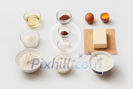 Top view of recipe with different ingredients for making cake. Ingredients for cooking represented separately over white background: oil, sugar, flour, butter, egg, etc.