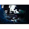 Silhouette of a scientist looking into microscope in a chemistry/physics lab (color toned image)