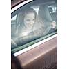 Woman driving a car - female driver at a wheel of a modern car, looking happy, smiling with a relaxed smile (shallow DOF; color toned image)