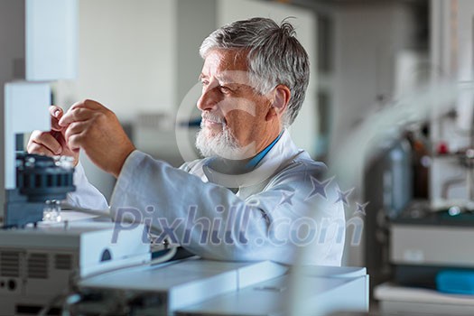 Senior chemistry professor/doctor carrying out research experiments in an analytical chemistry lab (color toned image) Senior chemistry professor/doctor carrying out research experiments in an analytical chemistry lab (color toned image)