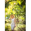 Pretty, young woman gardening in her garden, cutting branches, taking care of the fruit trees in her lovely orchard