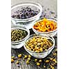 Assortment of dry medicinal herbs in glass bowls