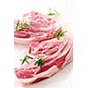 Two raw fresh lamb chops with rosemary herb