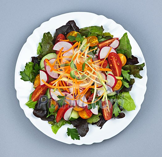 Plate of healthy green garden salad with fresh vegetables from above