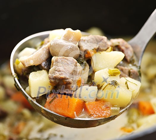 Hearty beef and potatoes stew with vegetables served with ladle Hearty beef and potatoes stew with vegetables served with ladle