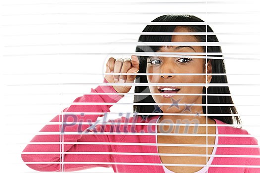 Young black woman looking through horizontal venetian blinds